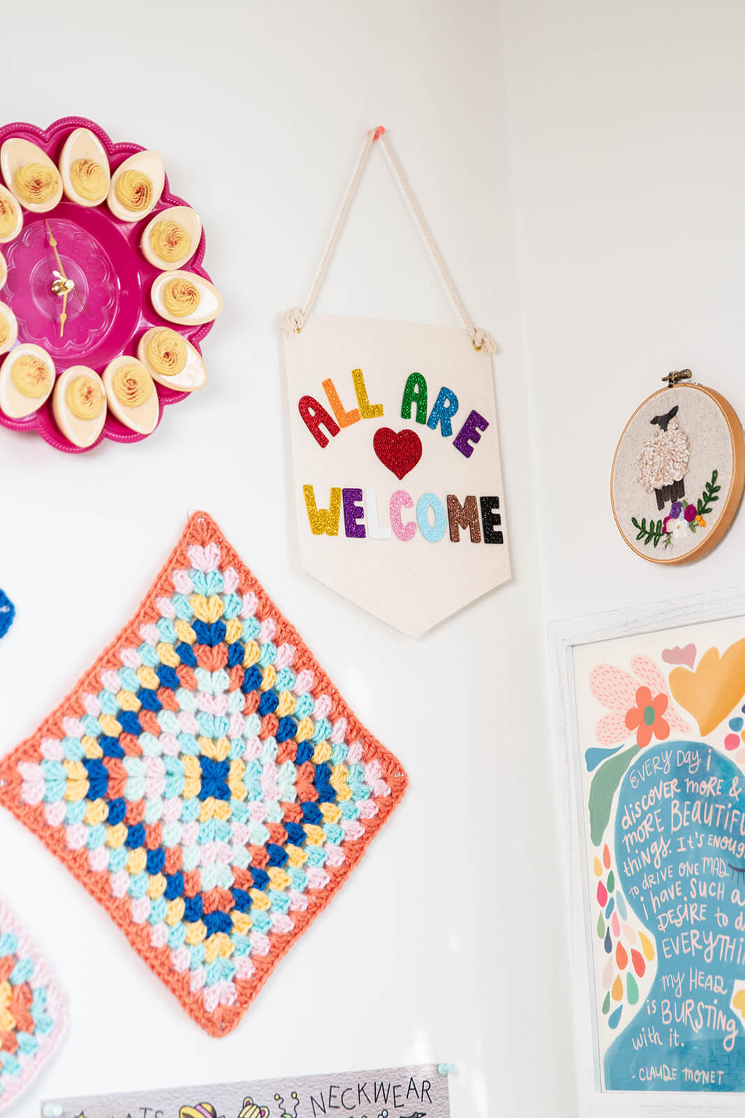 A Pennate on the wall that reads "All are welcome" in rainbow letters.
